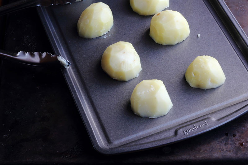 Steamed potatoes on baking sheet
