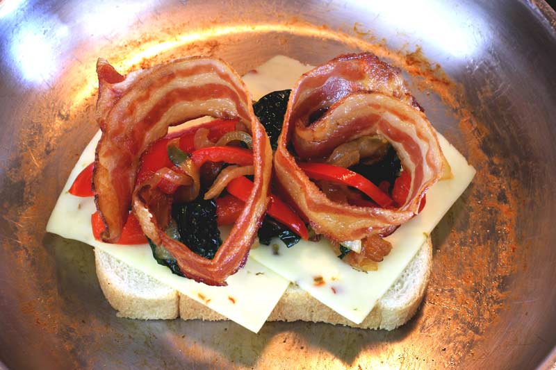 Assembly of grilled cheese pepper jack roasted red pepper caramelized onion spinach crispy bacon