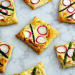 Lemon and Ginger infused cream cheese atop puff pastry and topped with Asparagus & Radish. My kids call them the healthy pop tarts, I call them party fab