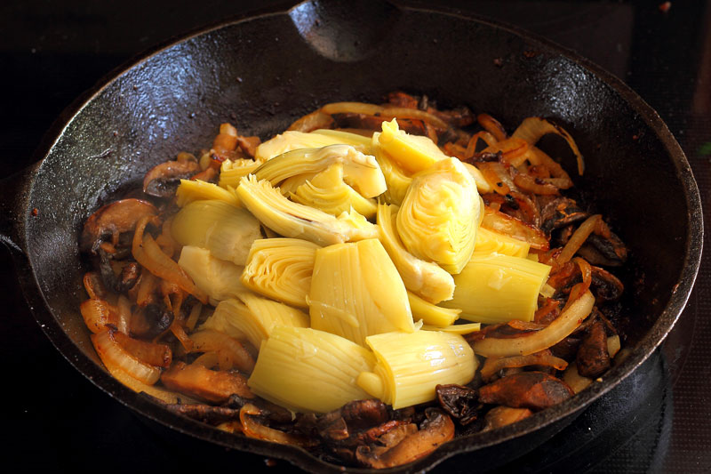 sausage and artichoke caramelized onion portobello mushrooms and artichoke hearts in cast iron skillet