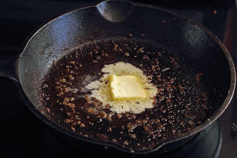 butter in cast iron skillet for sausage and artichoke